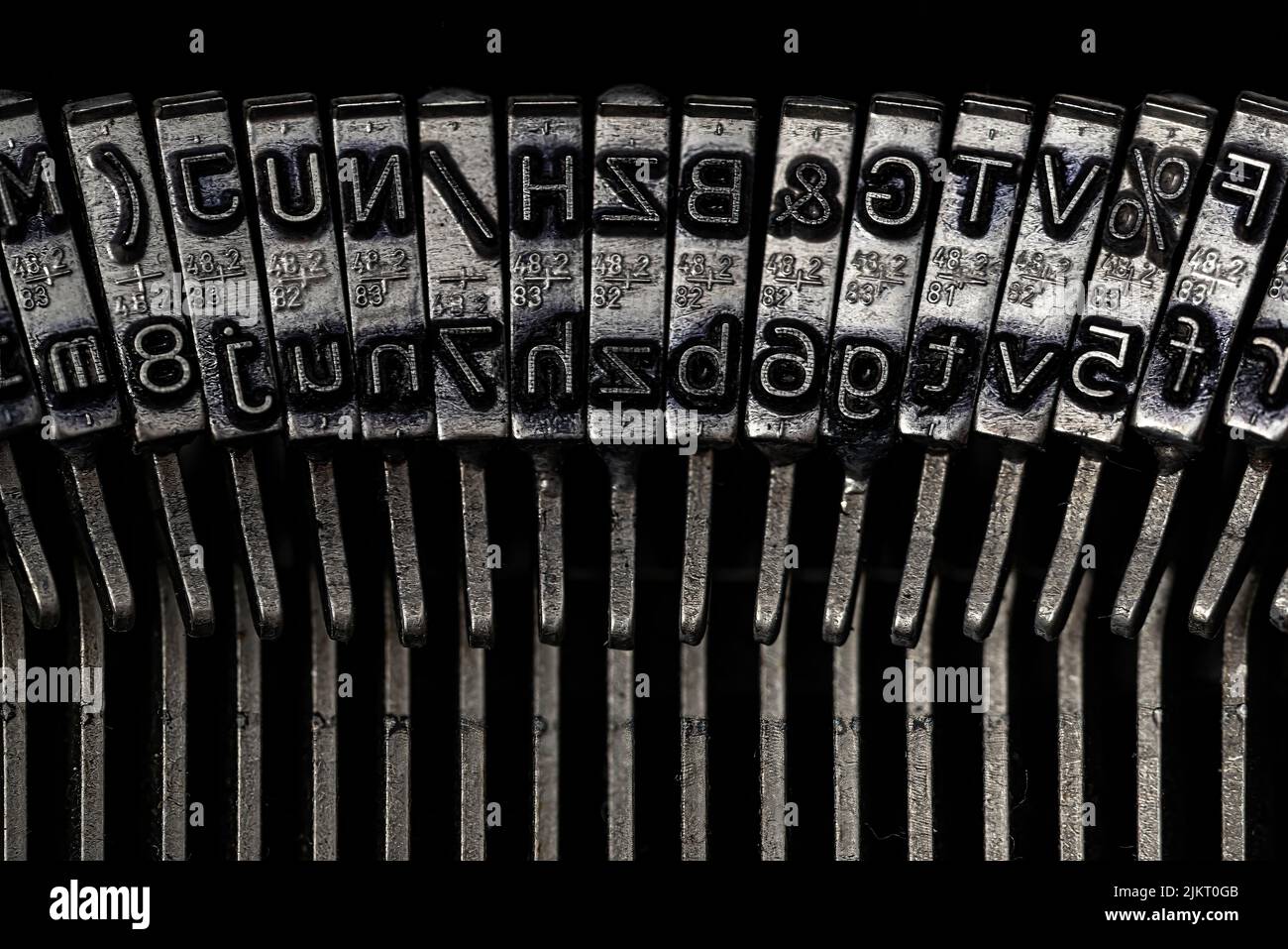 Nahaufnahme der Typenleisten einer mechanischen Schreibmaschine mit Buchstaben auf Schlagköpfen Stockfoto
