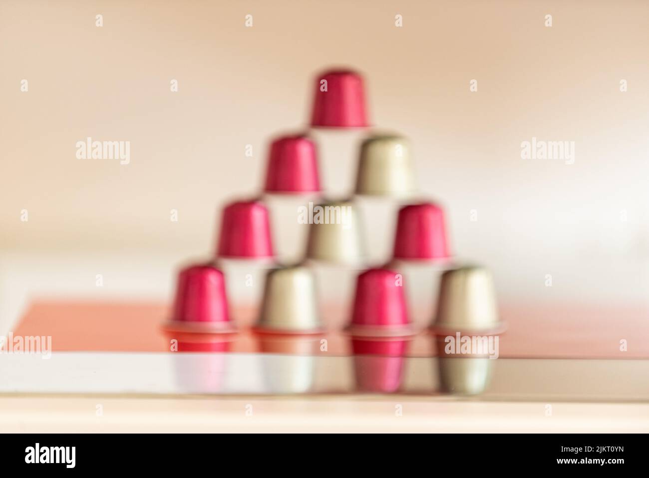Eine Pyramide aus italienischen Kaffeepads in rotem Boden Stockfoto