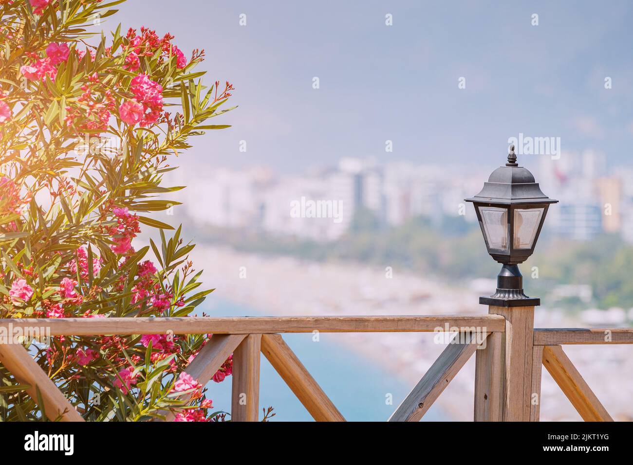 Berühmter Konyaalti Strand, landschaftlich schöner Panoramablick von einem Aussichtspunkt. Dekorative Laterne und Holzzaun und blühende Blumen im Frühling. Reisedesti Stockfoto
