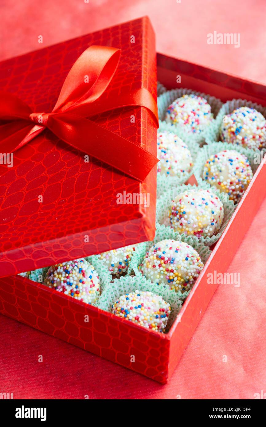 Hausgemachte Marzipankugeln aus Mandeln in einer roten Schachtel. Stockfoto