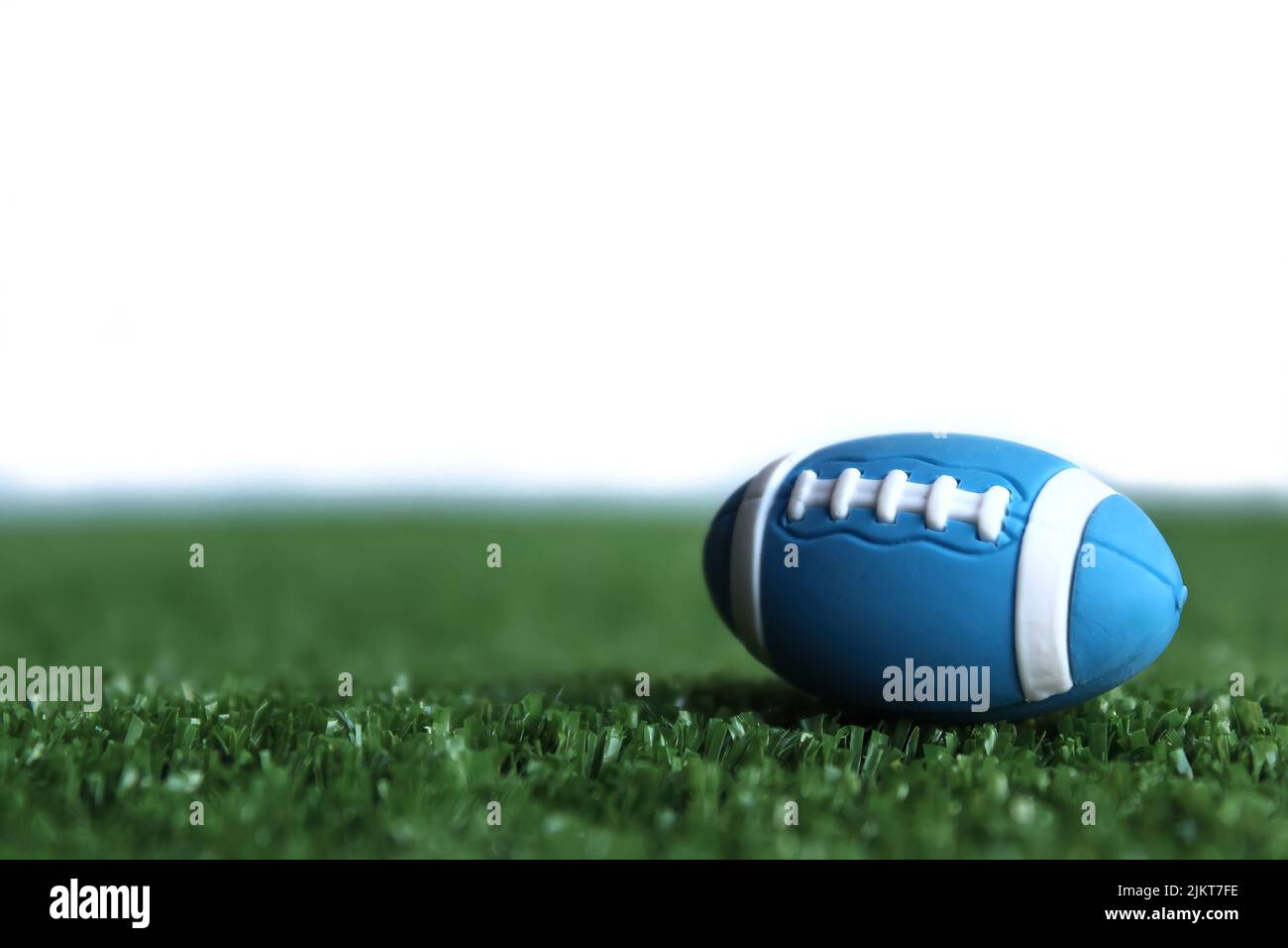 Selektives Fokusbild von Rugby-Ball auf Rugby-Pitch-Gras isoliert auf weißem Hintergrund Stockfoto