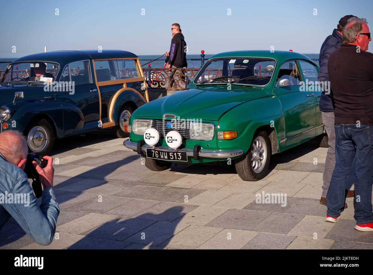 Ein Auto-Enthusiast fotografiert die klassische grüne SAAB 96 V4 Rallye aus dem Jahr 1970s auf der Bray Vintage Car Club Show. Eine Open-Air-Retro-Autos Display. Stockfoto