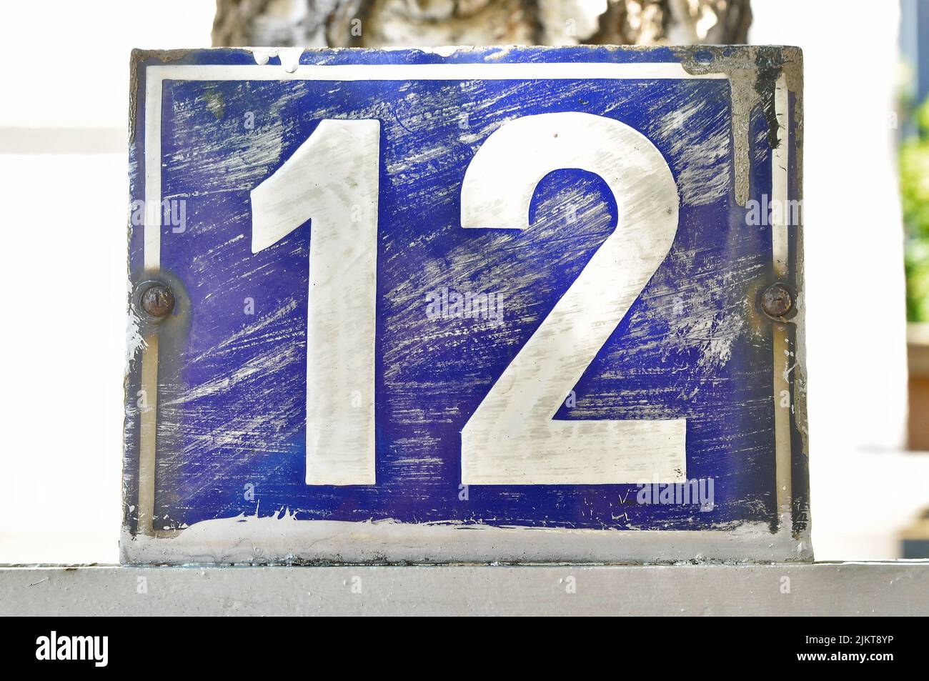 Eine blau-weiße Tafel mit der Hausnummer zwölf (12) Stockfoto