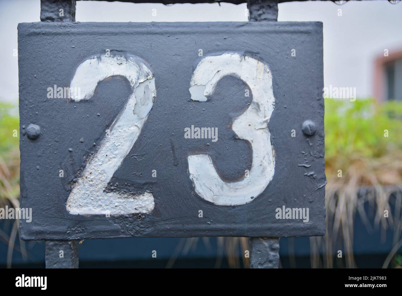 Nahaufnahme des Hinweisschildes Nummer 23 auf grauem Hintergrund Stockfoto