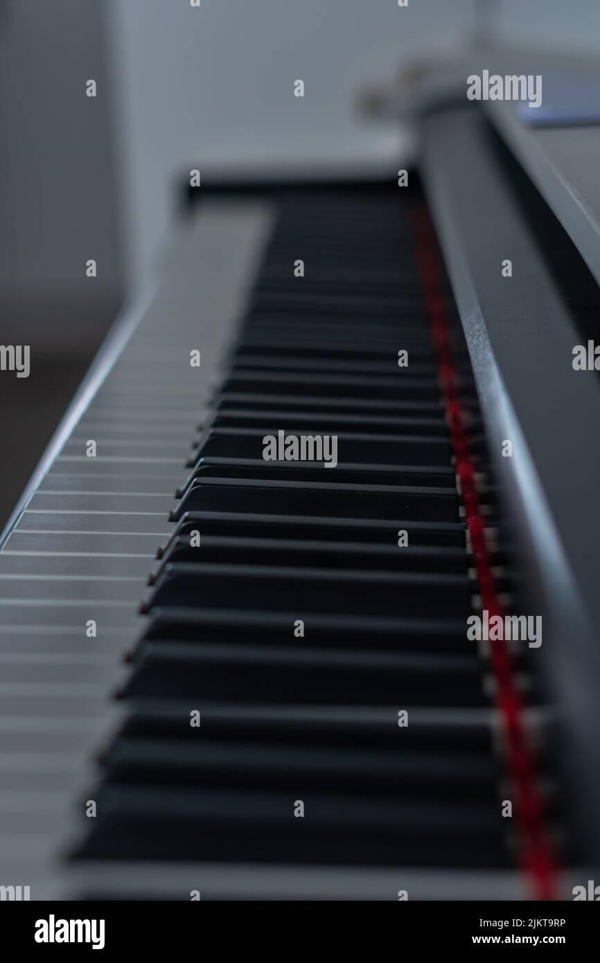Unscharf fokussierte Klaviertasten mit geringer Schärfentiefe und roten Tönen Stockfoto