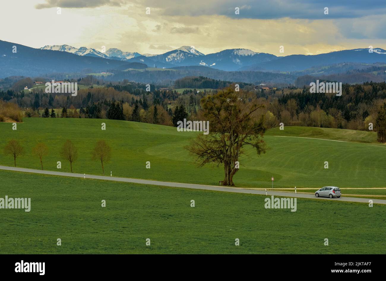 Eine atemberaubende Gegend hat grüne Landschaft mit kleinem Auto auf der Straße durch österreichische Alpen nach Italien. Stockfoto