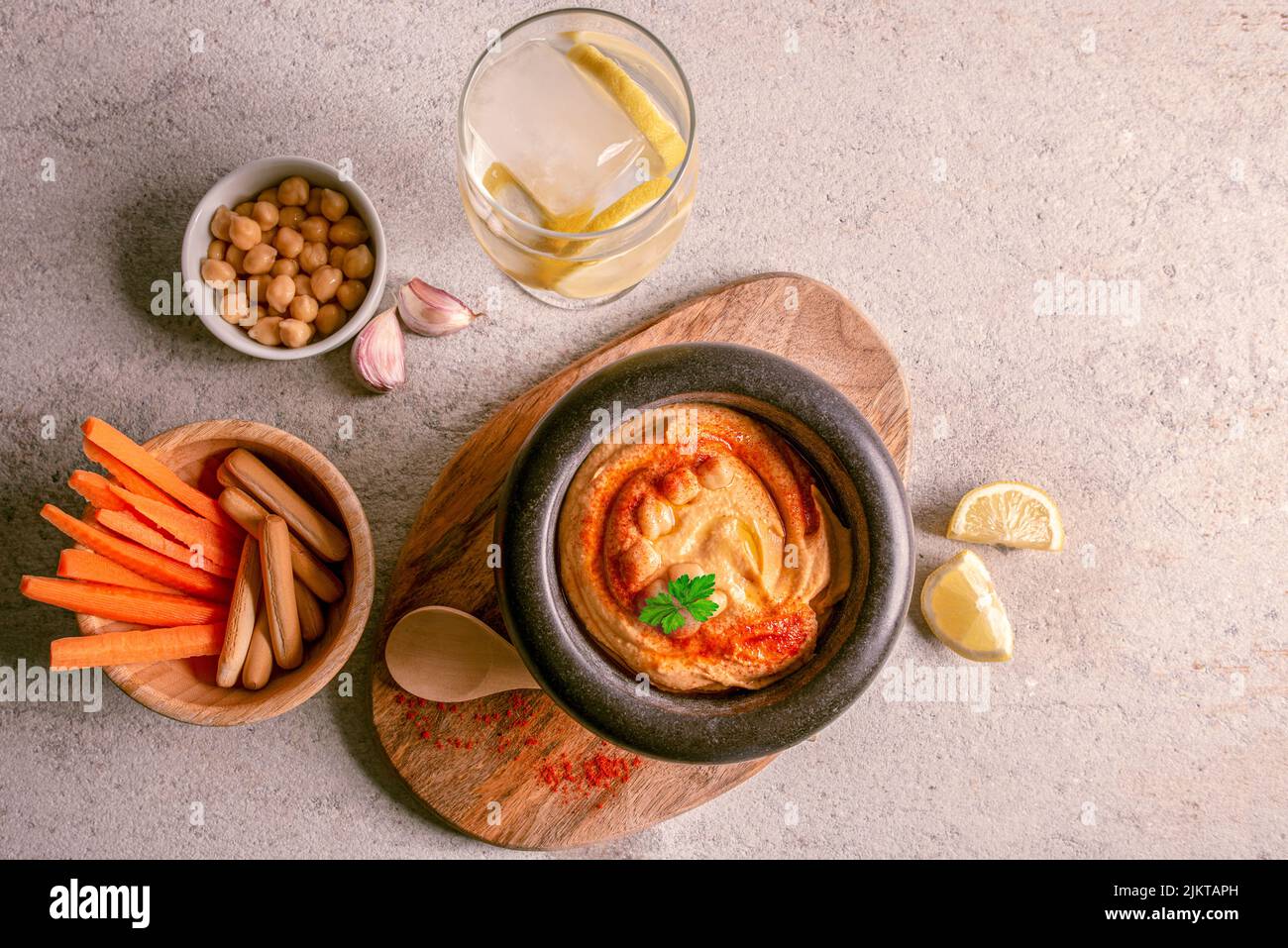 Hausgemachter Hummus mit Karottensticks, Olivenöl, Paprika, Zitrone Stockfoto