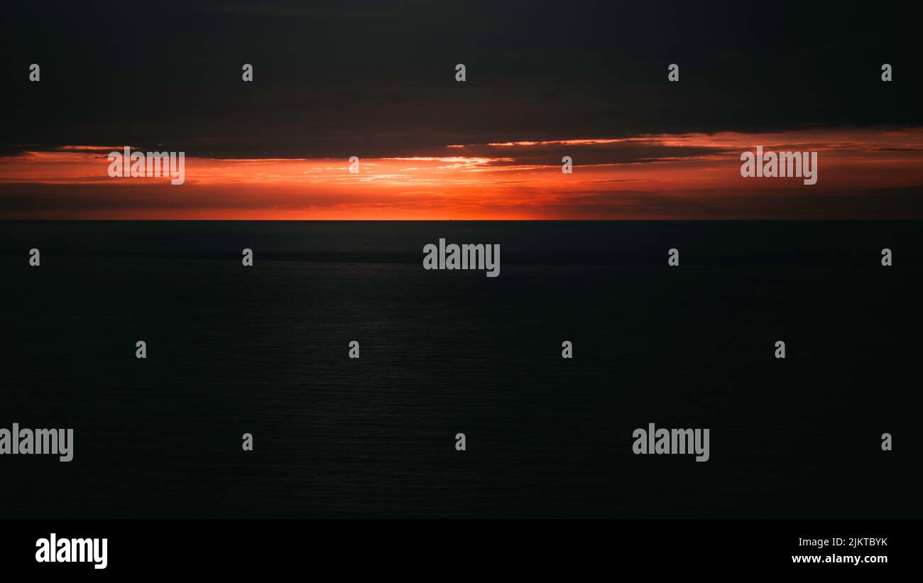 Ein schöner Blick auf einen orangen Sonnenuntergang über dem Meer Stockfoto