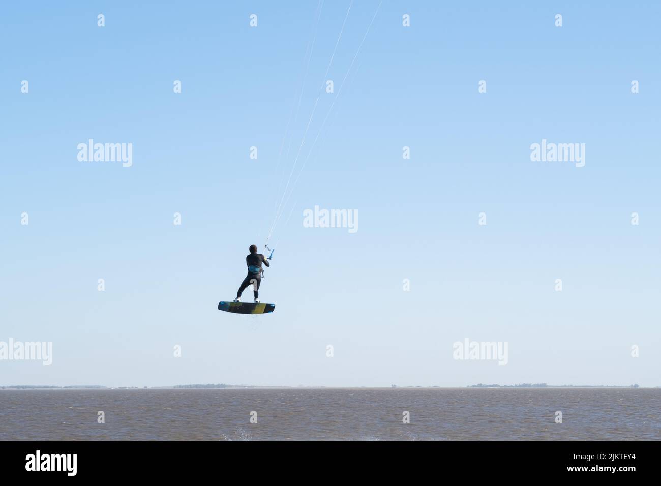 Eine Person, die einen Kitesurfing-Trick ausführt Stockfoto