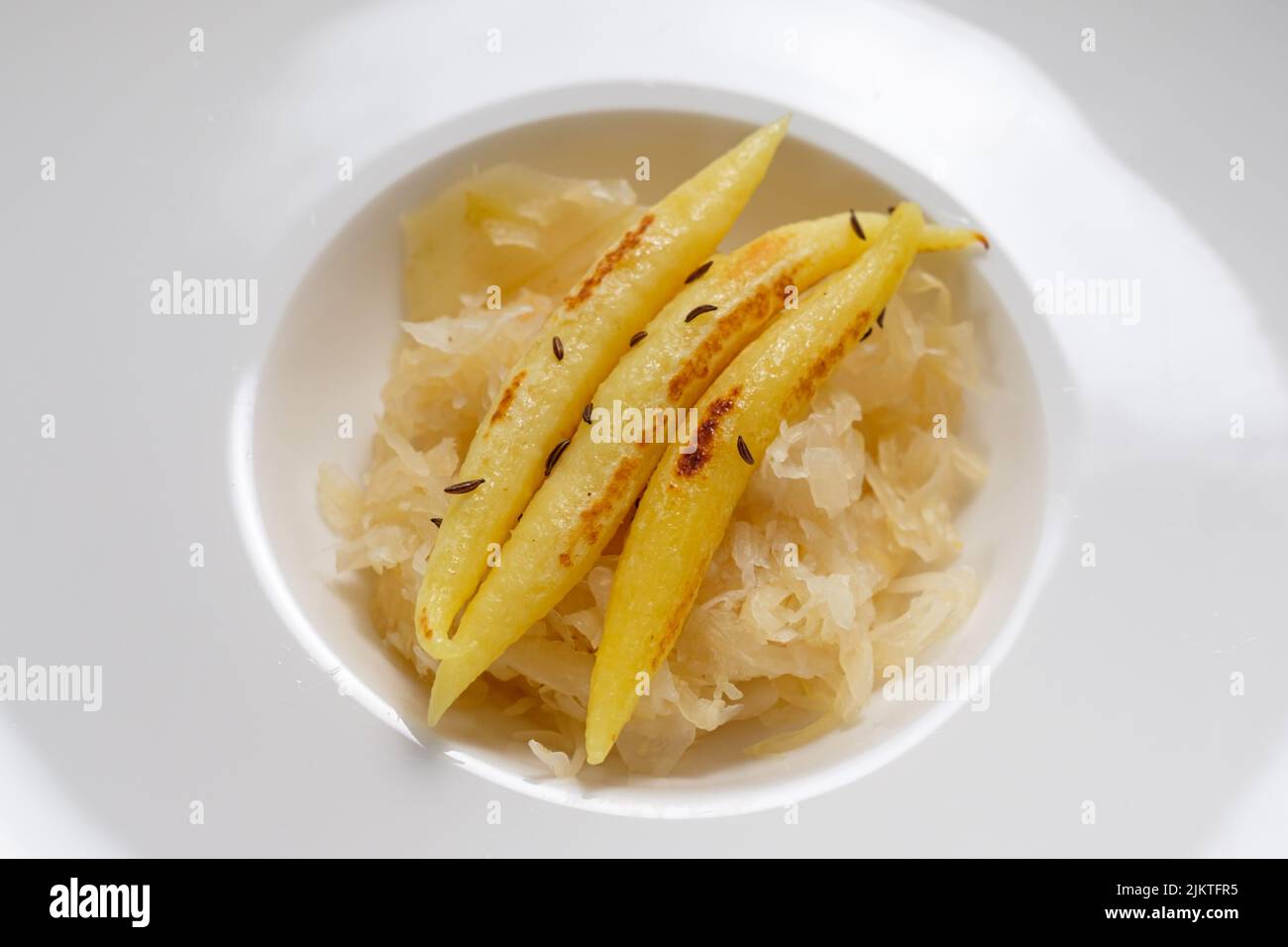 Fingerförmige Kartoffelknödel auf Sauerkraut-Gericht in einem Restaurant Stockfoto