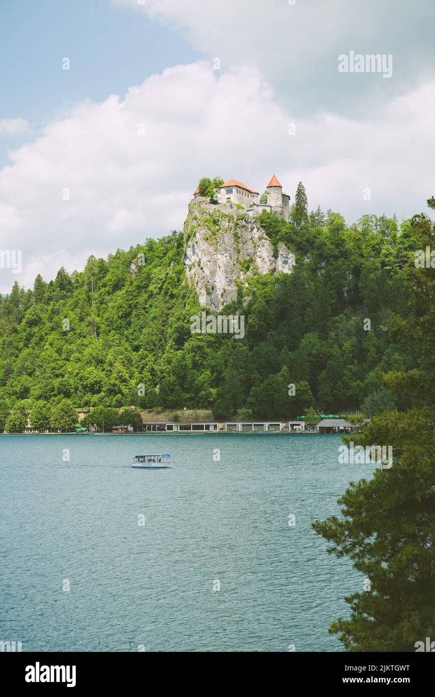 Eine vertikale Aufnahme von einigen Häusern, die auf einer Klippe, umgeben von Bäumen, im Hintergrund von Bergen aufgestellt sind. Stockfoto
