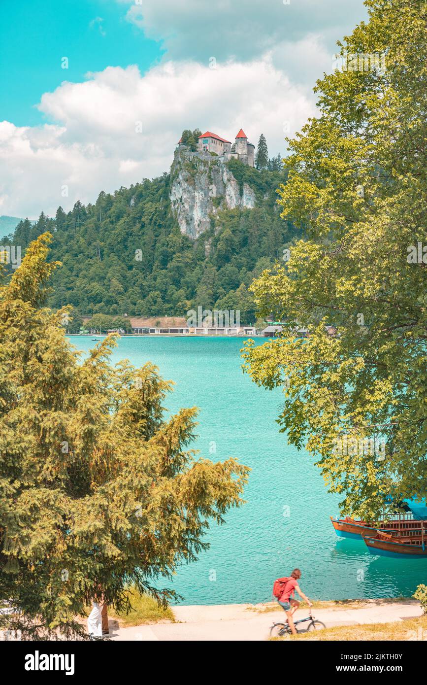 Eine vertikale Aufnahme von einigen Häusern, die auf einer Klippe, umgeben von Bäumen, im Hintergrund von Bergen aufgestellt sind. Stockfoto