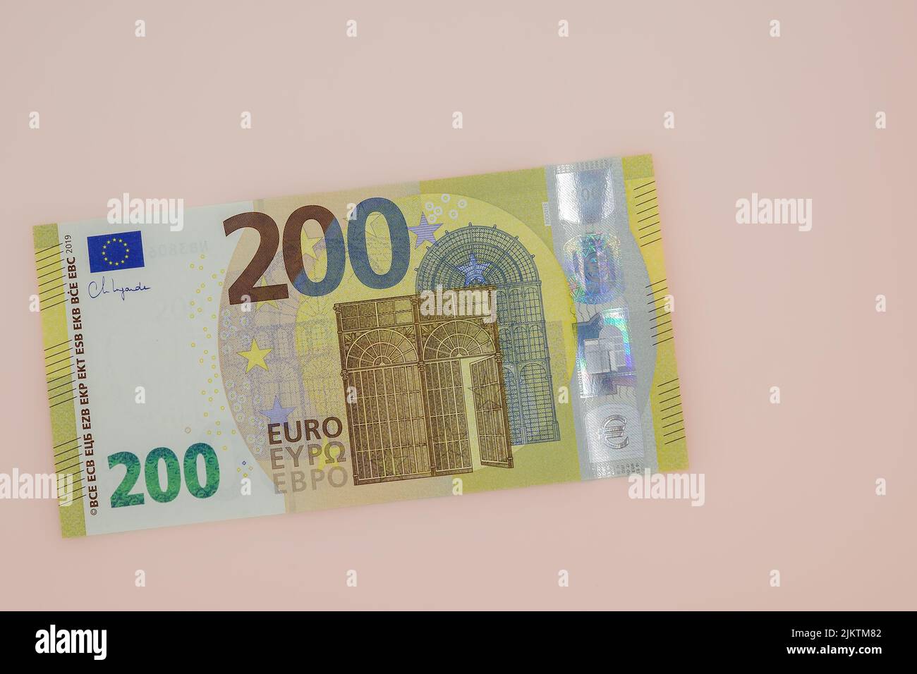 Eine Nahaufnahme einer 200-Euro-Banknote auf dem Hintergrund einer hellpfirsichfarbenen Note. Stockfoto