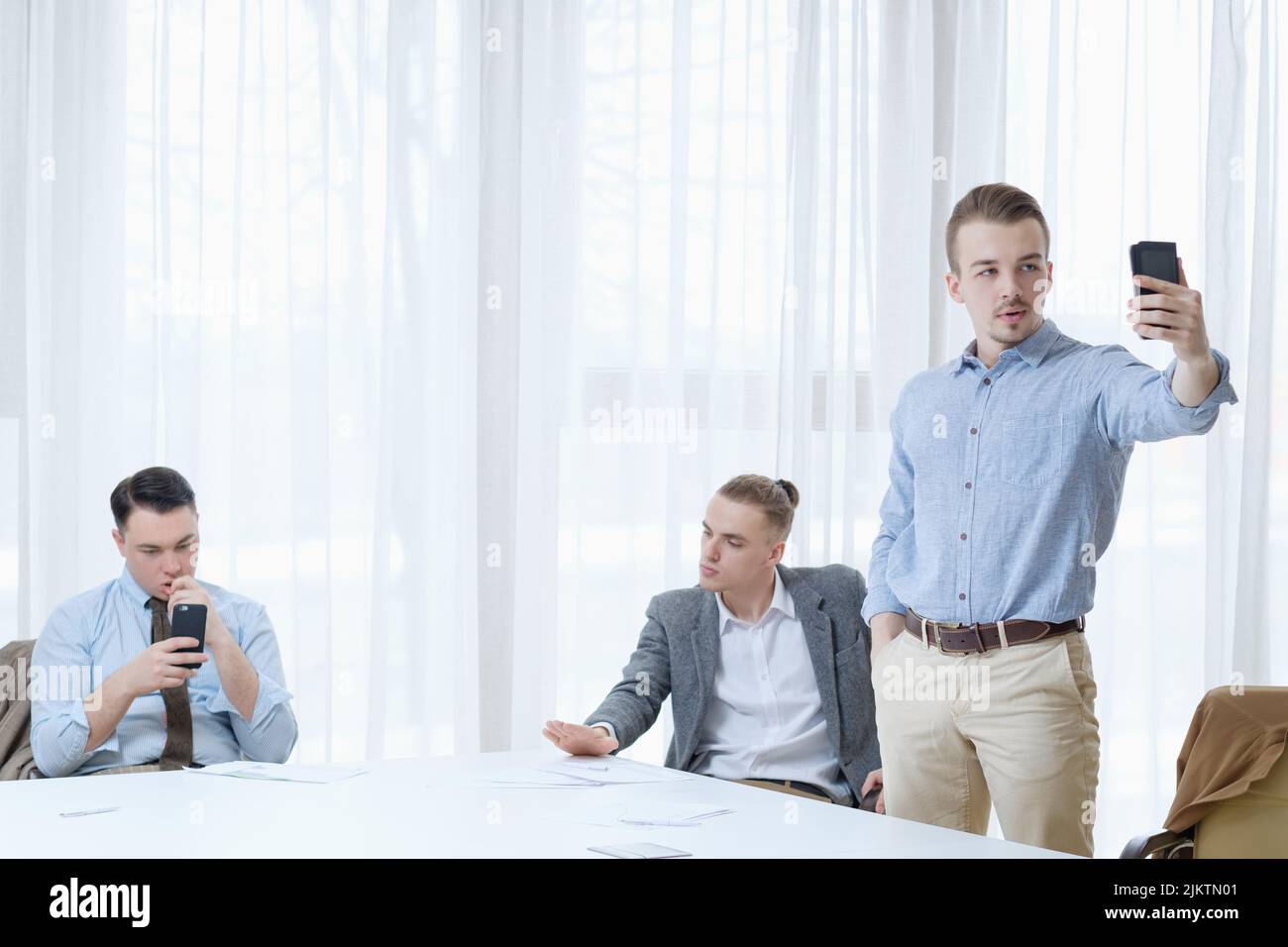 Gelangweilte Geschäftsleute treffen auf unnützes Selfie-Telefon Stockfoto