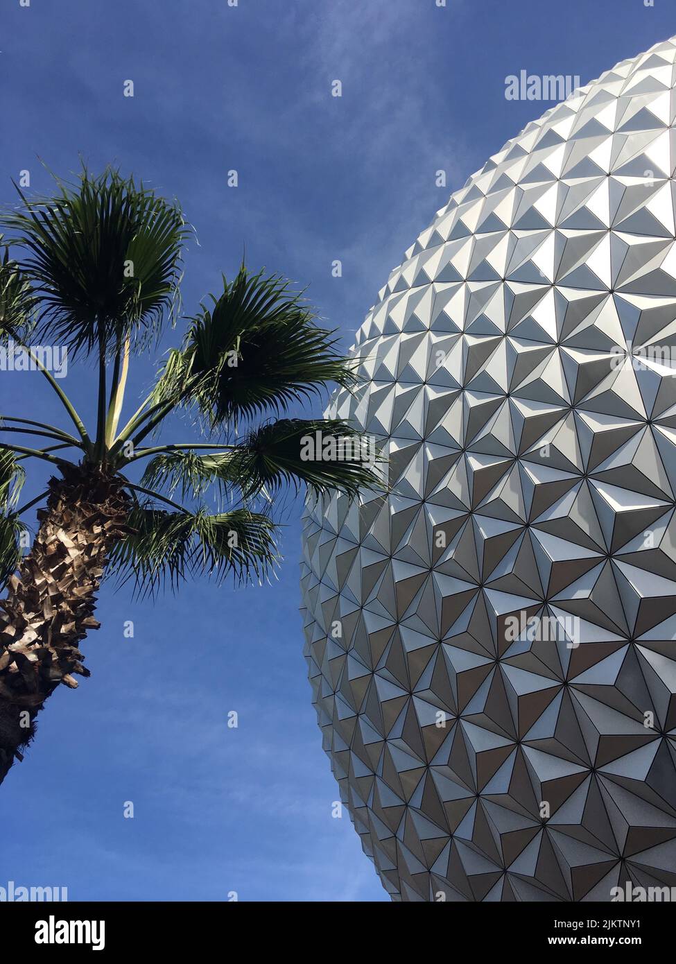 Palme mit der Geosphäre bei Disney's Epcot, die Raumschiff Erde beherbergt.weiß Stockfoto