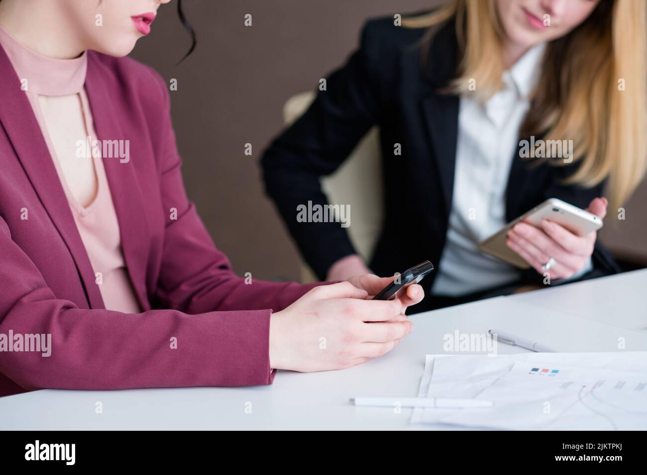 Gelangweilte Geschäftsfrauen im Büro, die nicht so gerne telefonieren Stockfoto