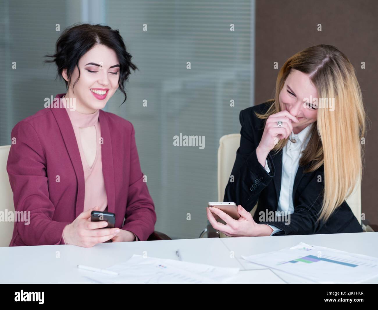 Untätige Angestellte, Handys, lachen Geschäftsfrauen Stockfoto