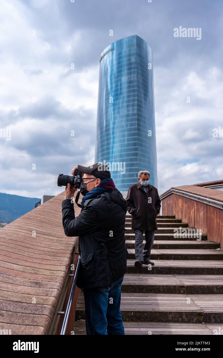 Ein Fotograf, der neben dem Iberdrola-Gebäude in der Stadt Bilbao, Vizcaya, Fotos macht. Baskenland Stockfoto