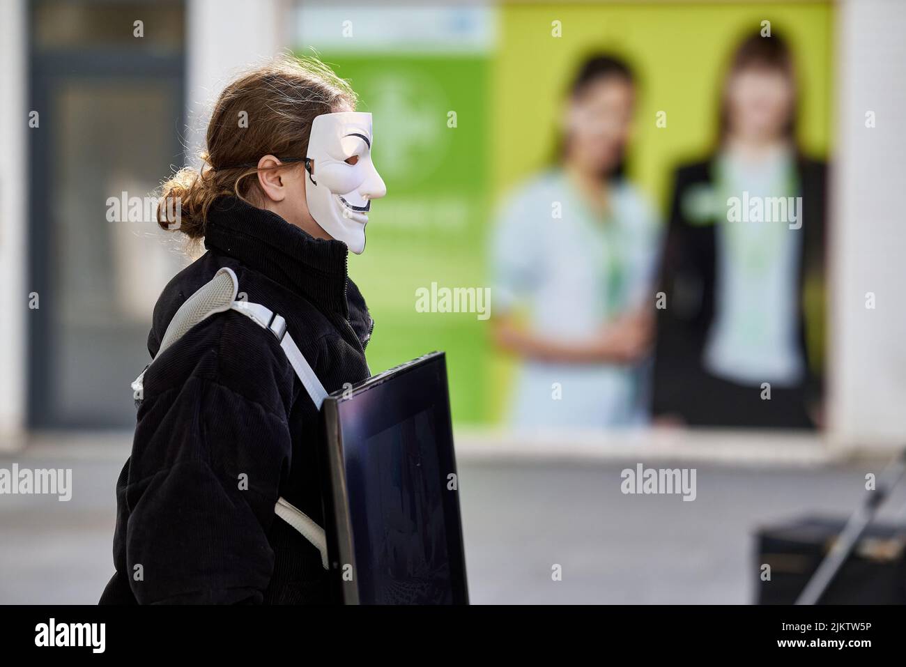 Eine Aktivistin, die auf den Straßen Großbritanniens eine anonyme Maske trägt Stockfoto