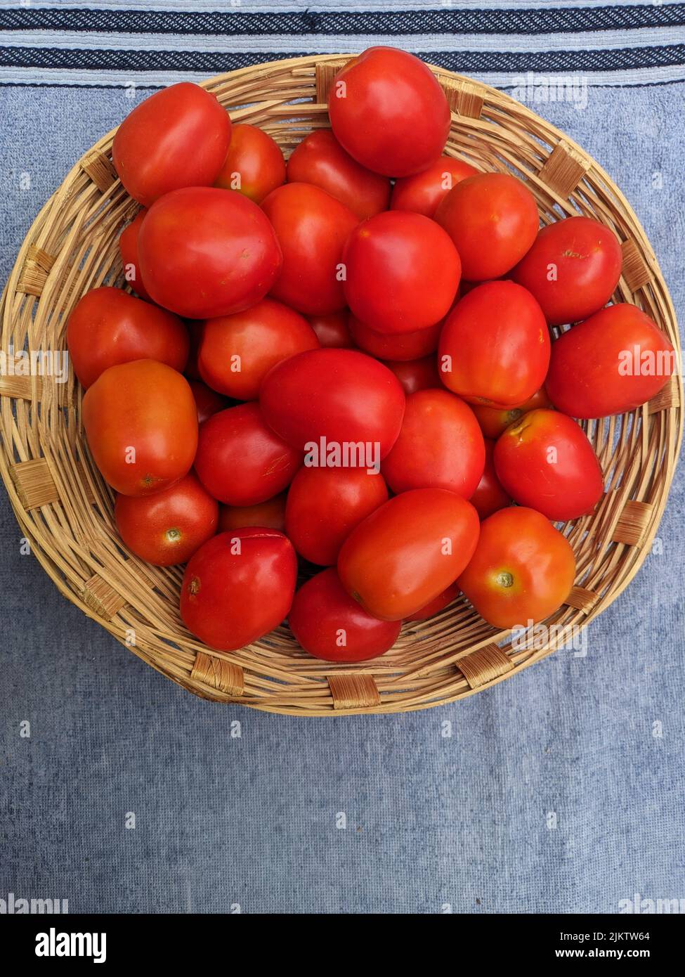 Frische rote reife Tomaten im Weidenkorb, rote Tomaten, Tomaten im Holzkorb, Gemüsefrüchte, Tomaten, Korb, rot, Frisch, f Stockfoto