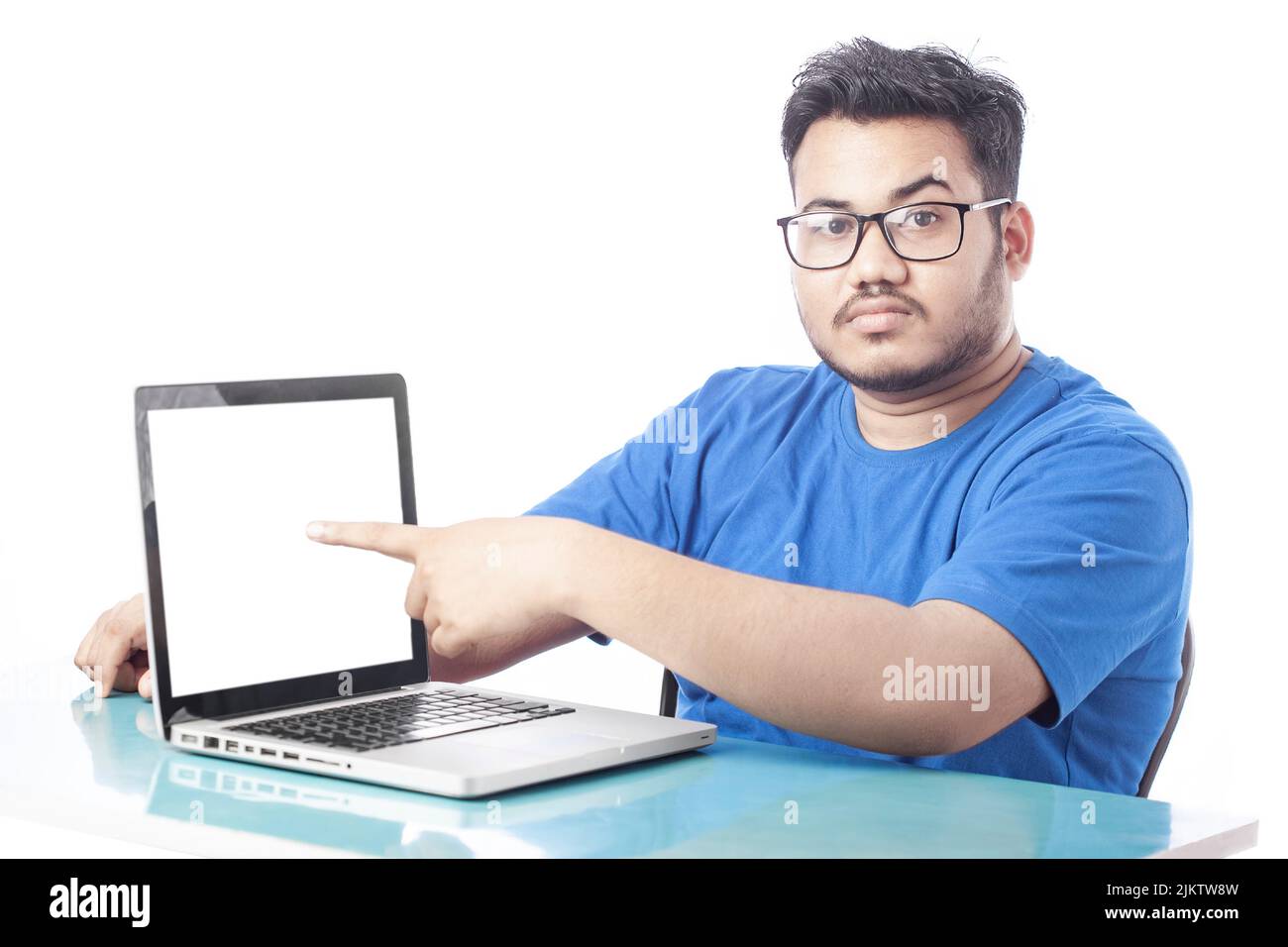 Junger Mann mit leerem weißen Laptop-Bildschirm und Zeigefinger Stockfoto