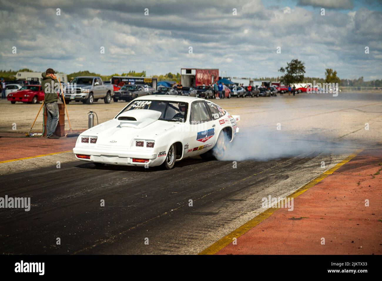 Lustige Auto-Dragster tun einen Burnout mit Rauch vor Drag-Rennen. Burnout an der Startlinie der Gimli-Motorsportbahn Stockfoto