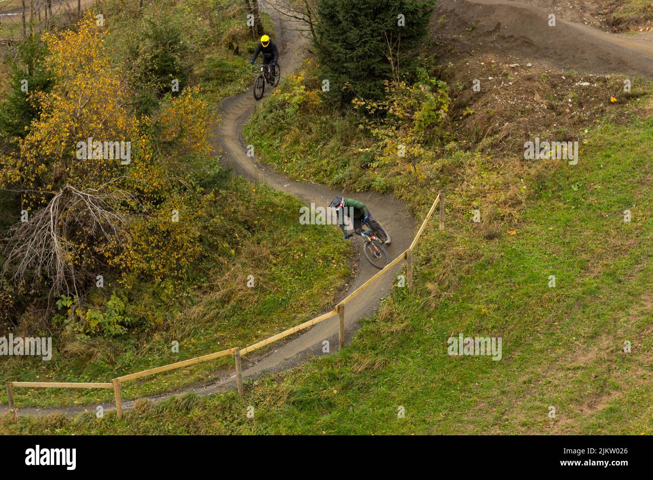 Ein Radrennen auf einer ländlichen Linie zwischen grünen Hügeln und einigen Bäumen Stockfoto