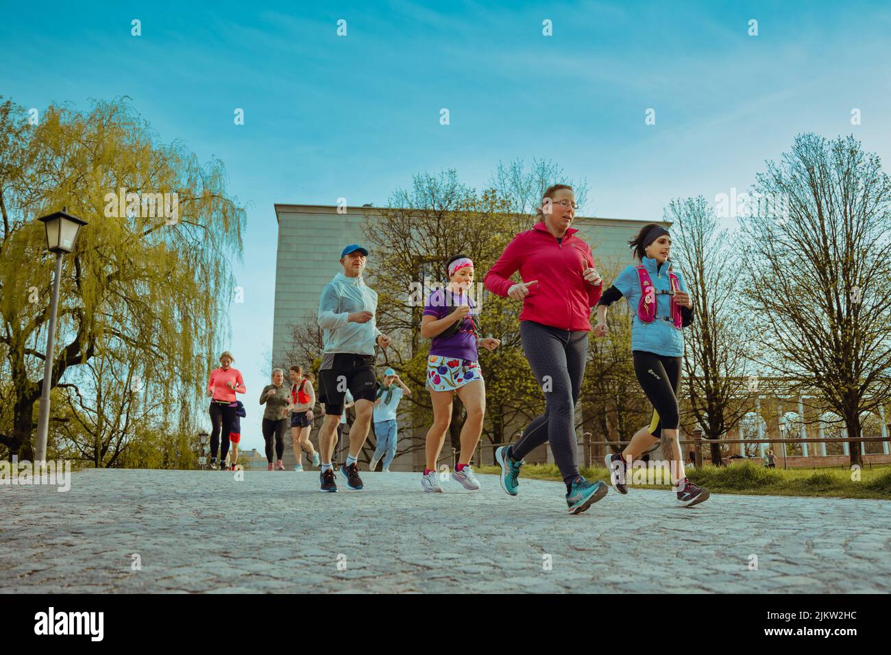 Jogginggruppe läuft durch den Park in München. Sportler trainieren im Frühjahr für die Sommerfigur Stockfoto