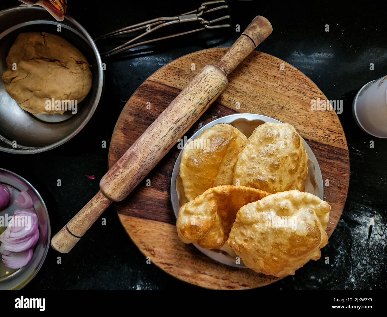 Stock Foto von köstlichen heißen frittierten puri oder bhatura aus Weizenmehl oder Allzweck-Mehl in Stahlplatte zum Servieren gehalten. Holzrollen bo Stockfoto