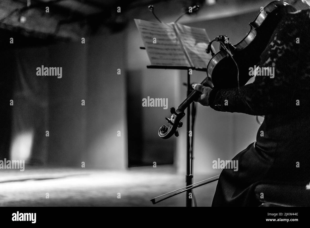 Eine Graustufenaufnahme eines Geigers mit der Geige Stockfoto