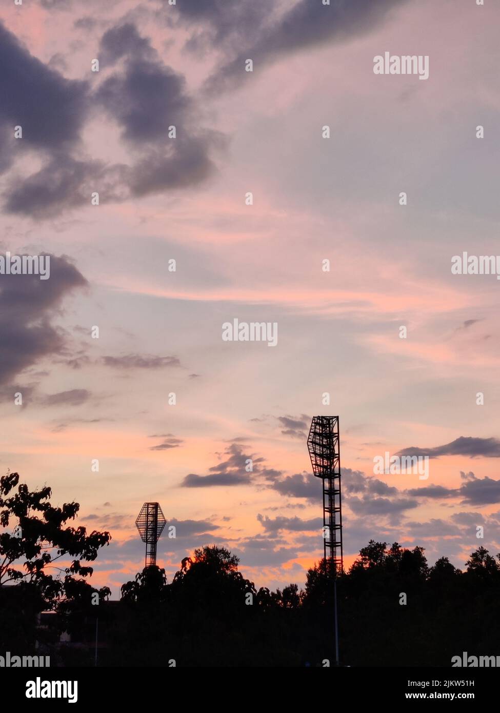 Wunderschöne rosa und orange Sonnenuntergang hinter dem Plovdiv Stadion. Magische Stunde. Lichttürme gesehen. Romantische Industrie. Stockfoto