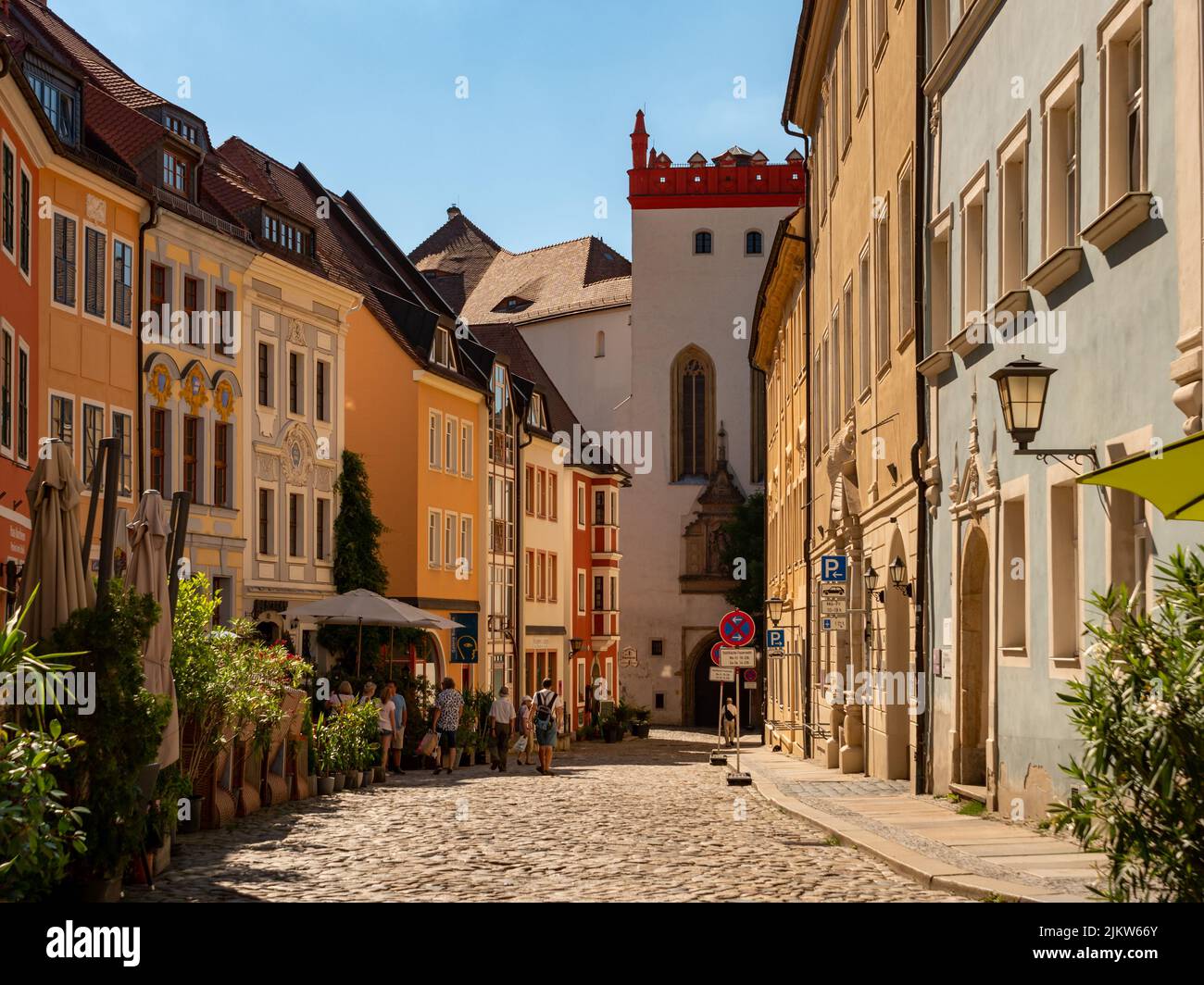 Die Leute im Stadtzentrum laufen herum. Restaurants neben der alten Straße. Schöne kleine Gebäude in einer Reihe. Die Altstadt ist ein wunderschöner Ort. Stockfoto