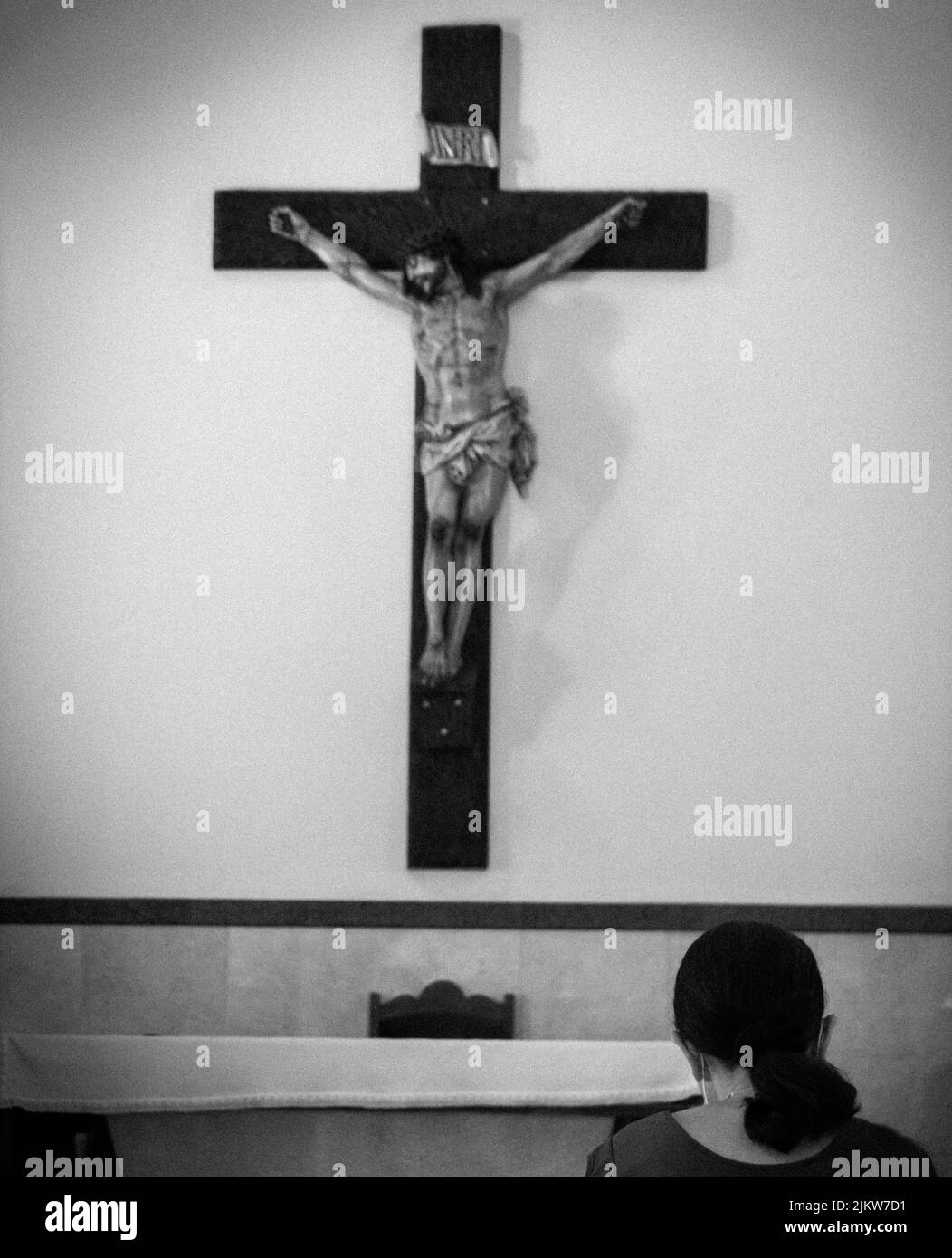 Eine vertikale Graustufenaufnahme eines Kreuzes in einer Kirche von Rio de Janeiro, Brasilien Stockfoto