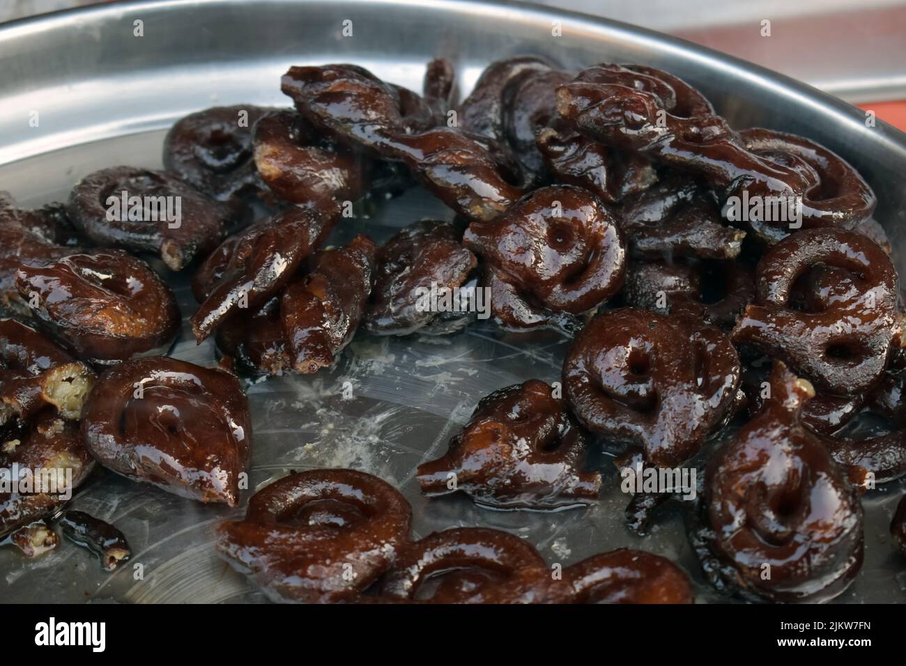 Ein Teller voller leckerer Mawa Jalebis. Indische Mawa Jalebi garniert mit trockenen Früchten Stockfoto