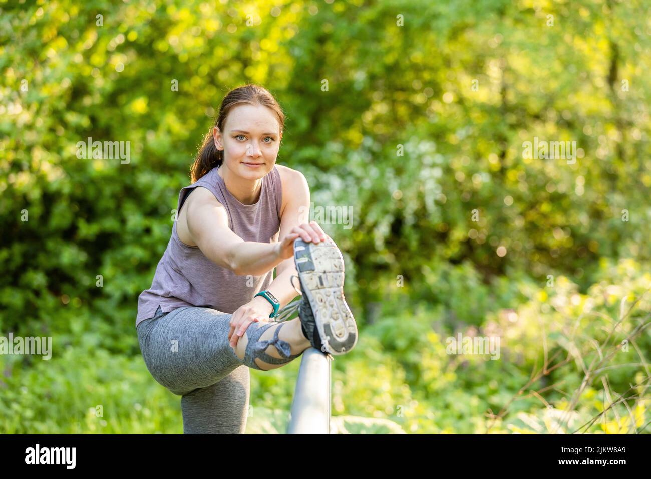 Junge Frau macht Dehnübungen in der Natur Stockfoto