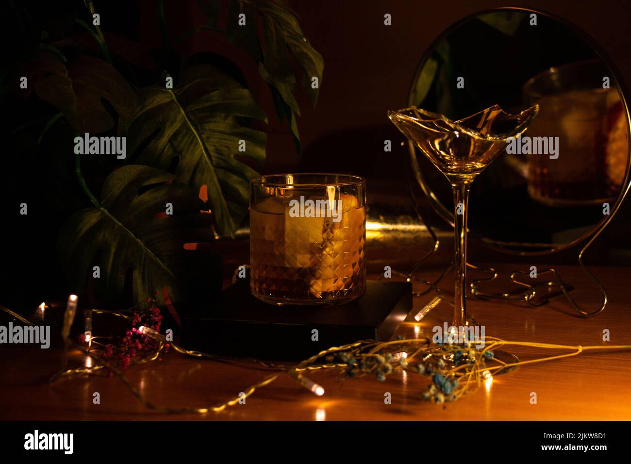 Negroni-Cocktail, orangefarbene Scheiben mit Spiegel, zerbrochenem martiniglas und hellem Hintergrund Stockfoto