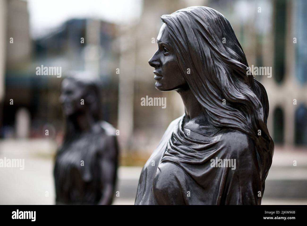 Eine Statue der 'Real Birmingham Family' vor der Bibliothek von Birmingham auf dem Centenary Square Stockfoto