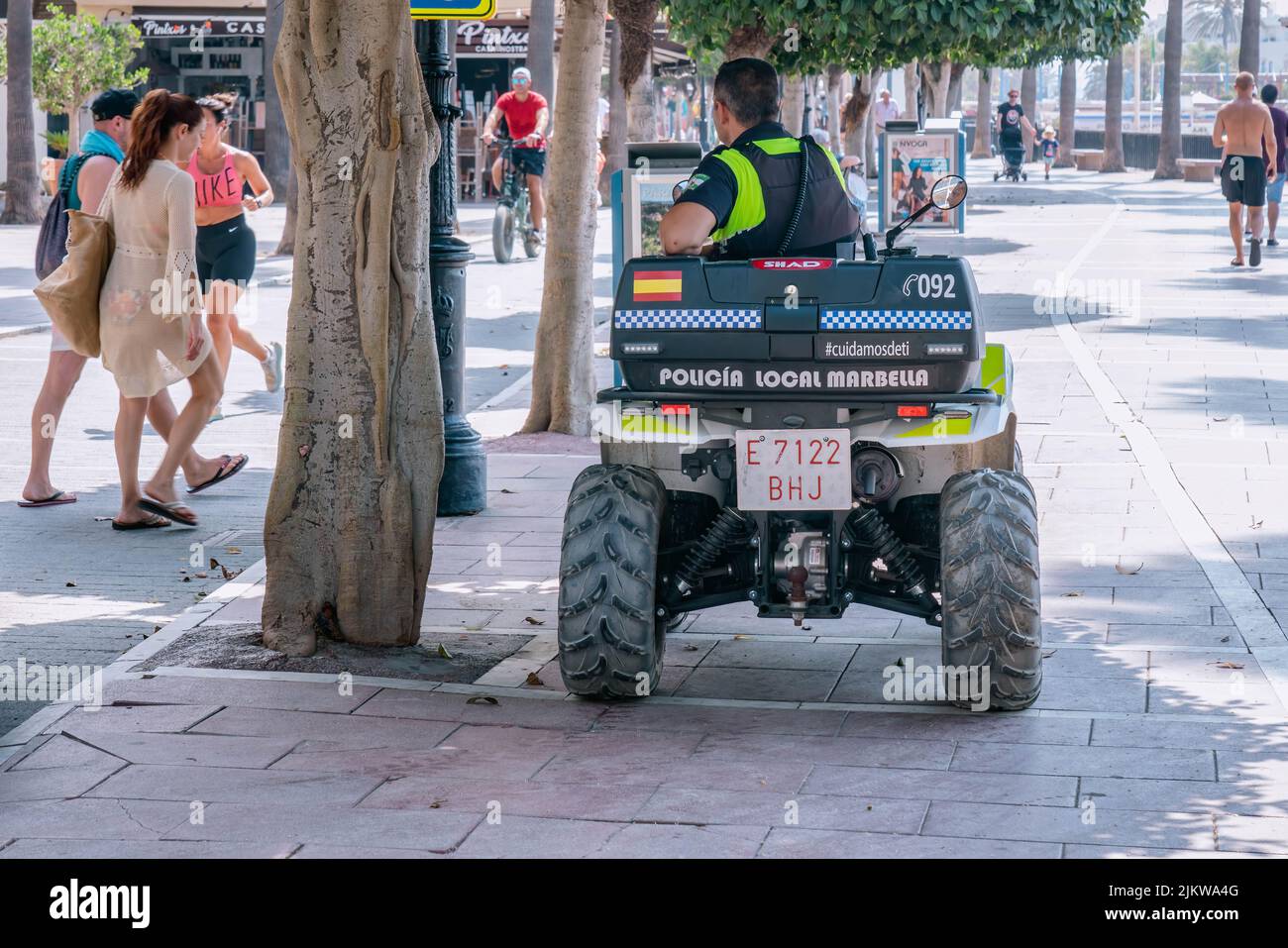 Spanische örtliche Polizisten auf Quad-Bike-Motorrad auf Touristenstraße. MARBELLA, MALAGA/SPANIEN - JULI 21 2022 Stockfoto