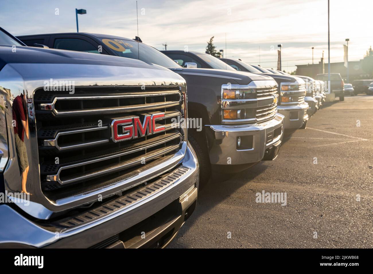 An einem sonnigen Tag stehen Lastwagen bei einem GMC-Händler zum Verkauf bereit Stockfoto