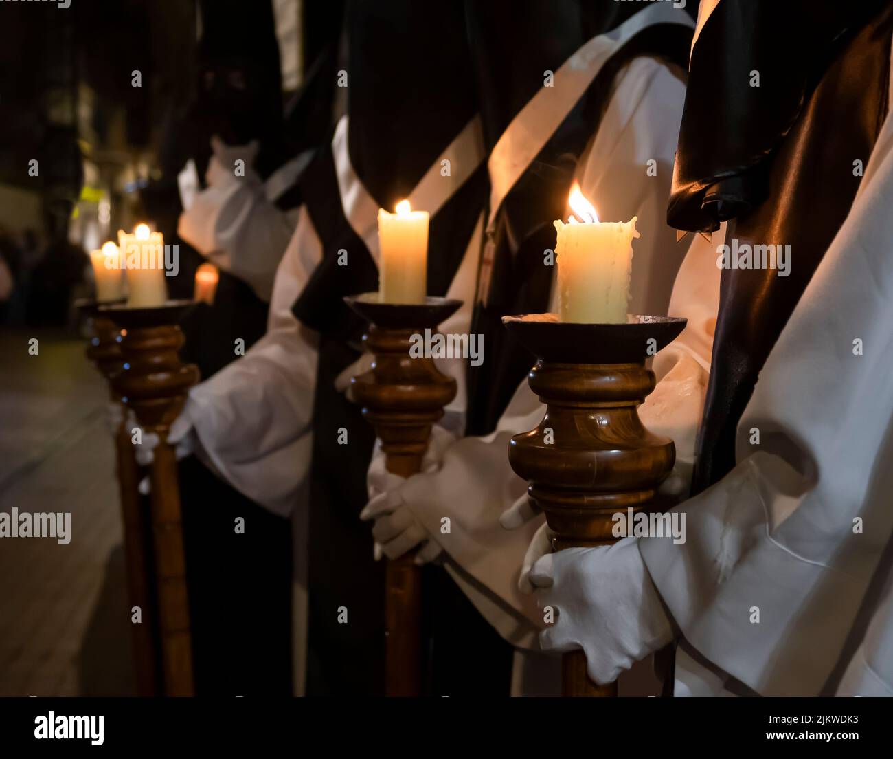 Semana santa Valladolid, varias velas encendidas portadas en báculos por hermanos de la cofradía de nuestro padre Jesús resucitado Stockfoto