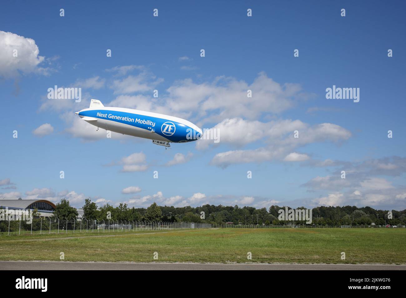 Ein Zeppelin Hangar fliegt über ein Feld in Friedrichshafen. Stockfoto