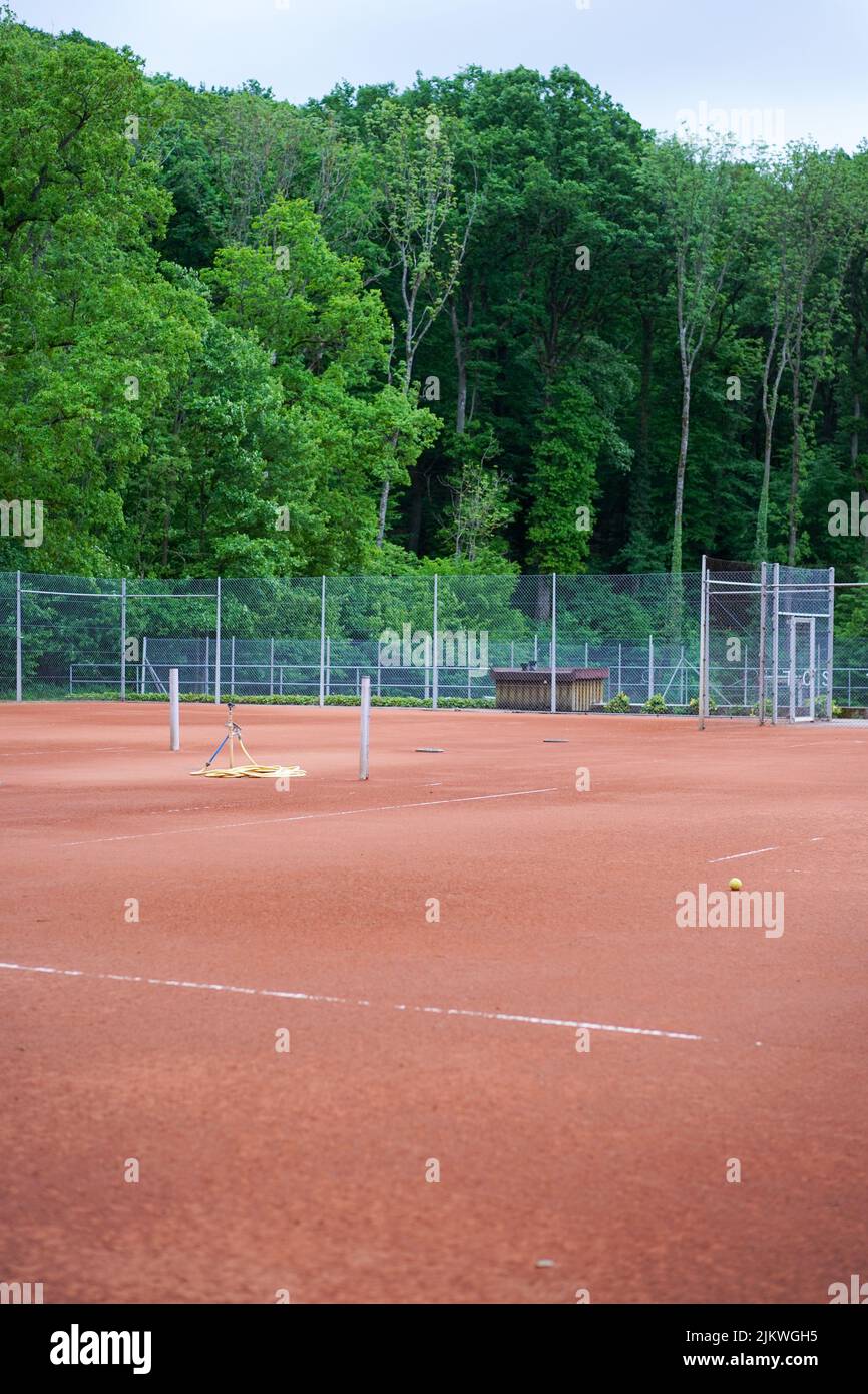 Eine vertikale Aufnahme eines Tennisplatzes in der Mitte eines Parks Stockfoto