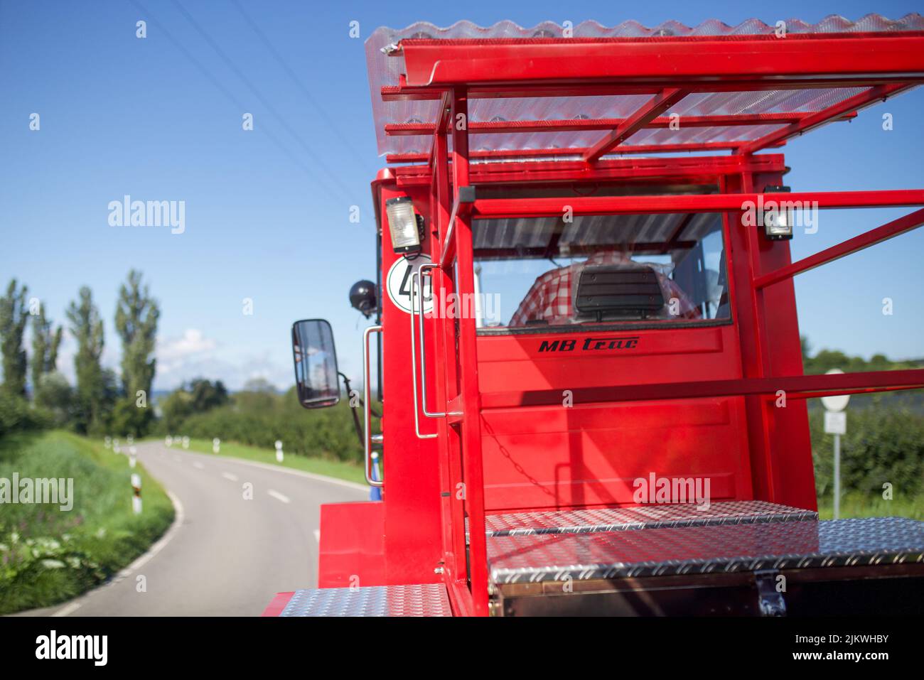 Eine rote Traktorfahrt durch die Obstgärten am Bodensee in Deutschland Stockfoto