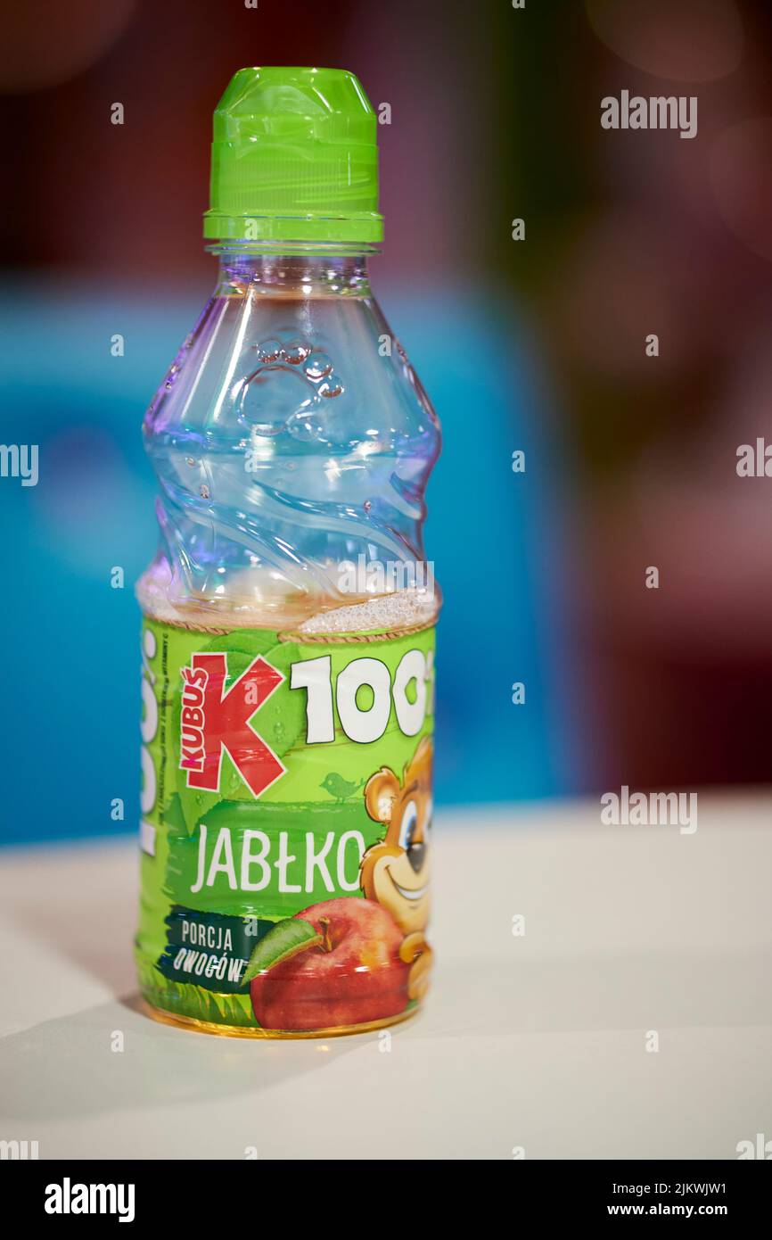 Ein polnischer Apfelsaft der Marke Kubus in einer geöffneten Plastikflasche auf verschwommenem Hintergrund Stockfoto