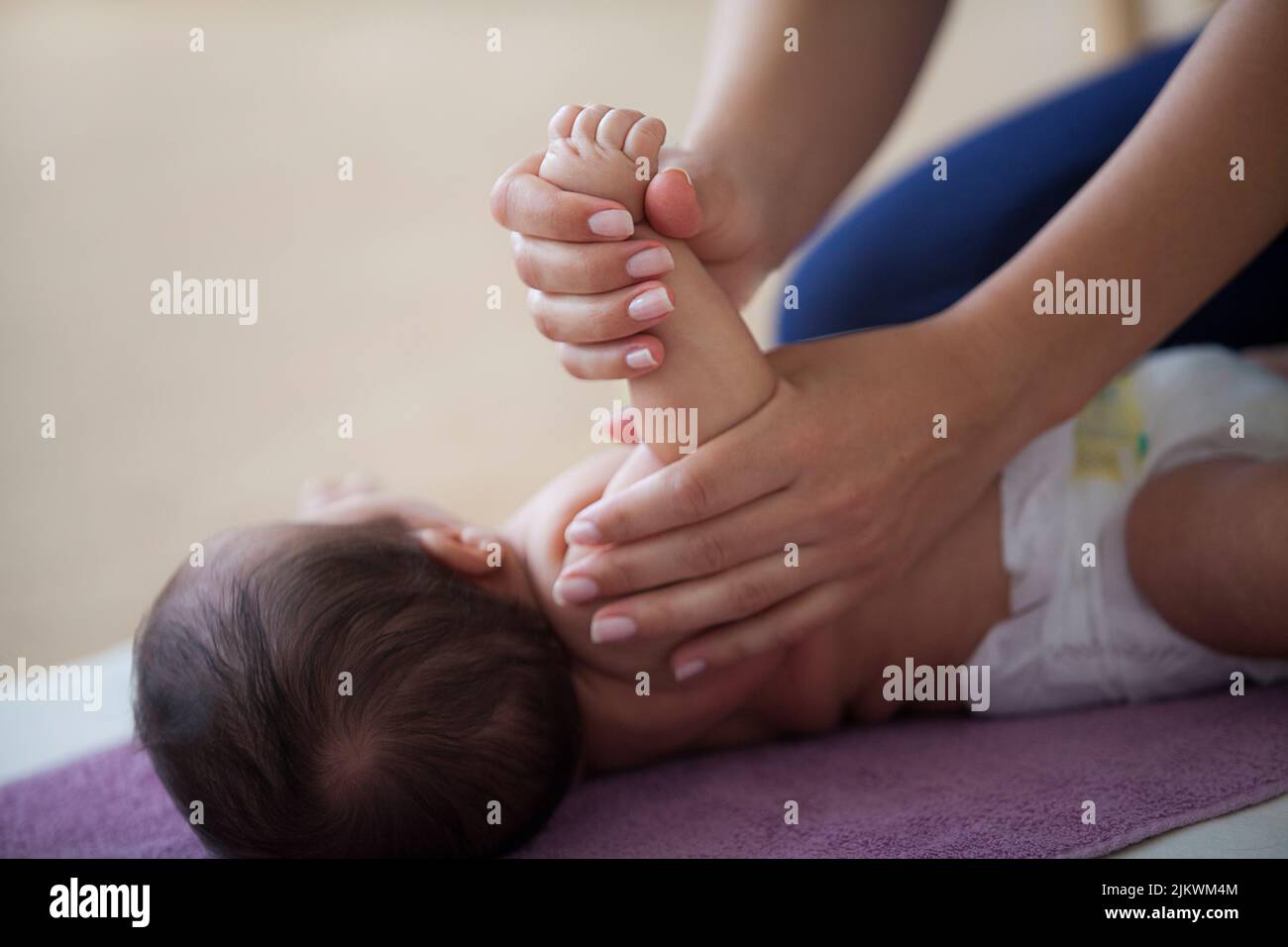 Massagekurse für Babys von jungen Müttern für das Wohlbefinden und zur Förderung der Bindung mit dem Kind Stockfoto