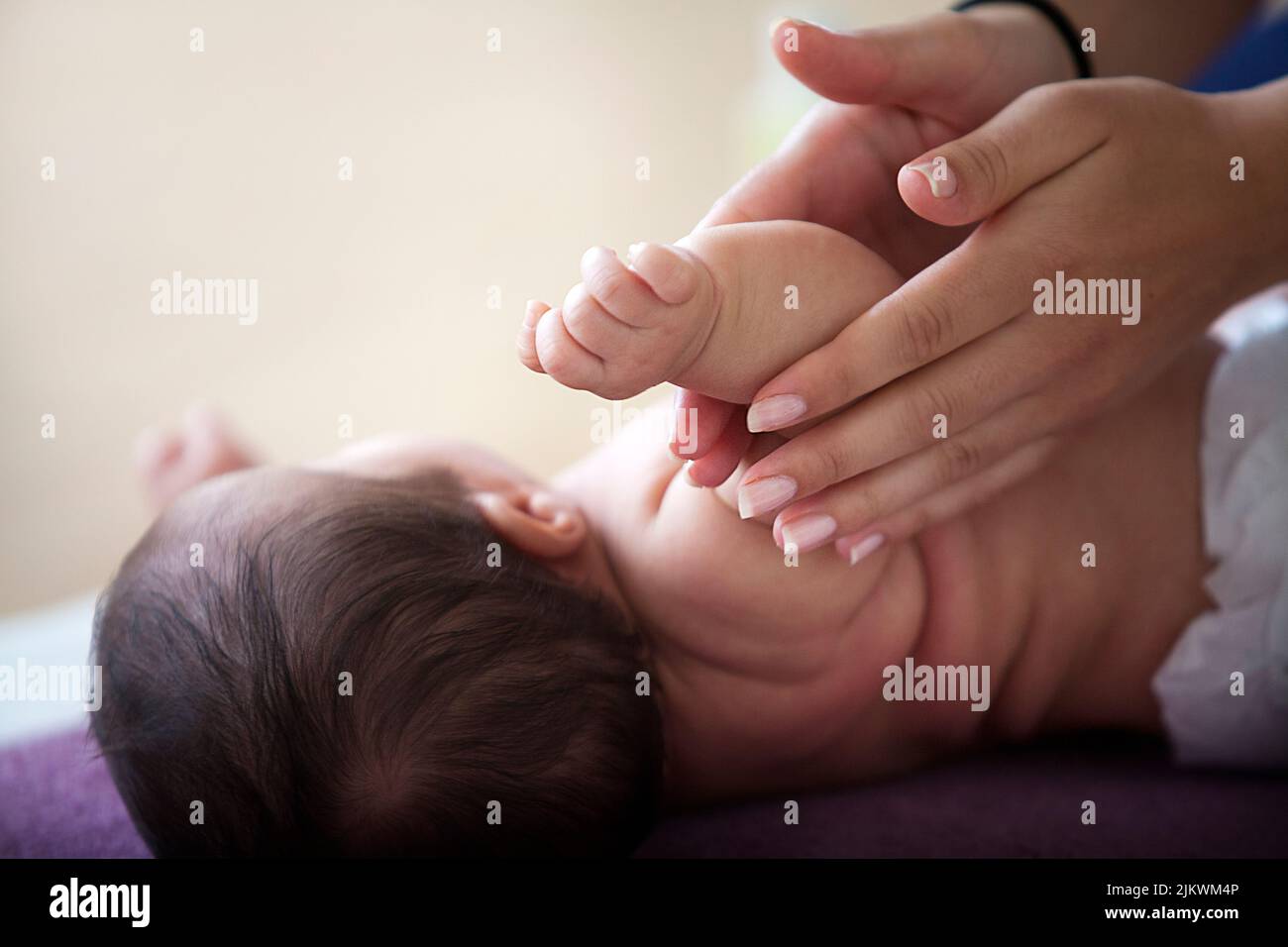 Massagekurse für Babys von jungen Müttern für das Wohlbefinden und zur Förderung der Bindung mit dem Kind Stockfoto