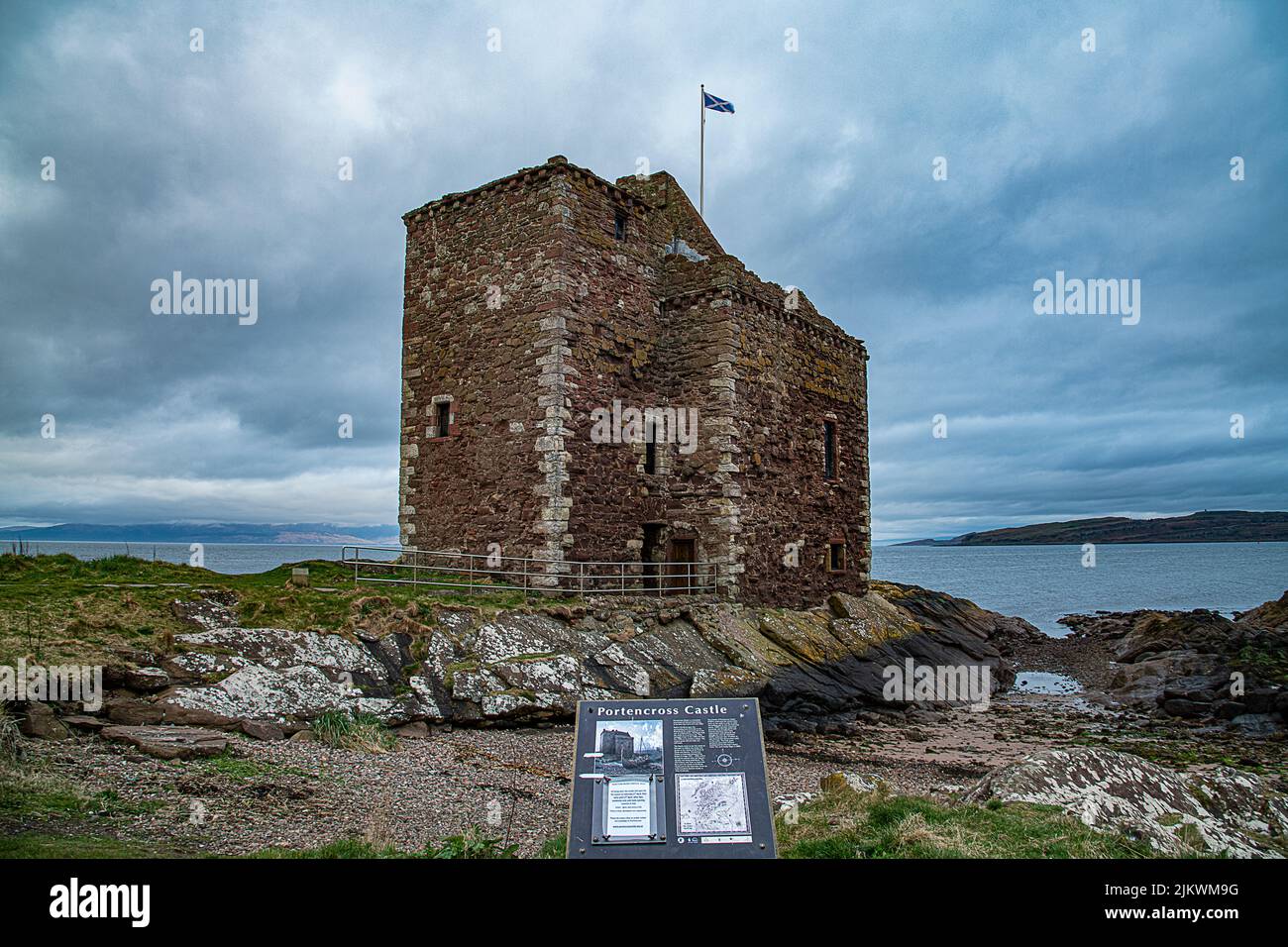 Ein schöner Blick auf das alte Schloss Portencross mit einer Flagge auf der Spitze vor dem Wasser Stockfoto