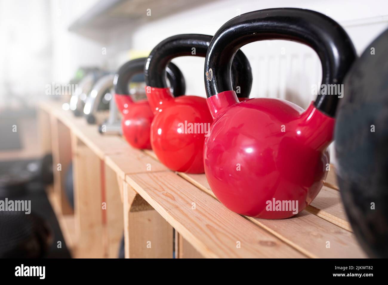 Eine selektive Fokusaufnahme von roten Kettlebells in einem Fitnessstudio Stockfoto