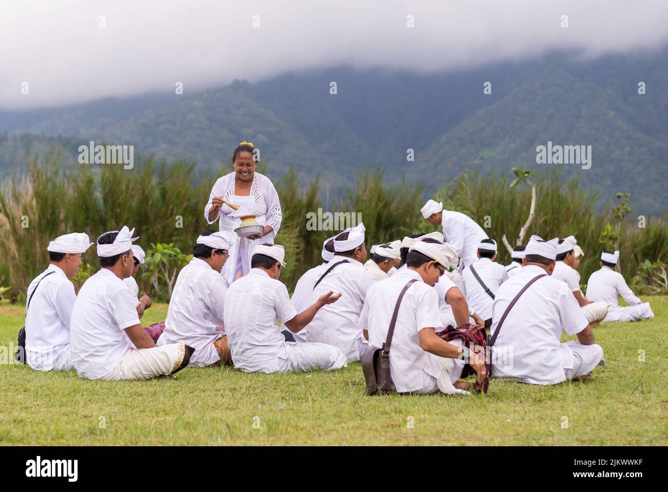 Gebetet Männer in weiß gekleidet mit Womat Pura Bratan Tempel auf See in Bali, Indonesien Stockfoto