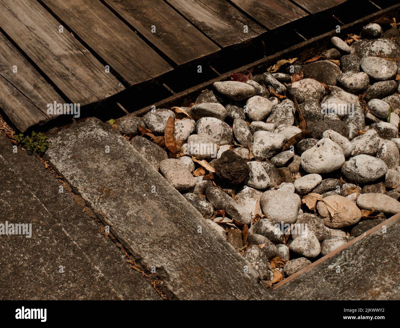 Nahaufnahme eines alten Bodens mit Holzteil und kleinen Steinen in einem Wohngebiet in Costa Rica Stockfoto
